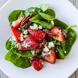 Fresh strawberry spinach salad bowl, showcasing bright red berries and creamy poppy seed dressing.