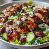 Greek Salad Bowl with Grilled Chicken, a colorful and hearty dish with juicy marinated chicken atop crisp lettuce, tomatoes, cucumbers, and feta.
