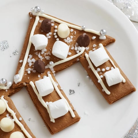 A beautifully decorated gingerbread house frame, creating a festive display with colorful candies and white icing.