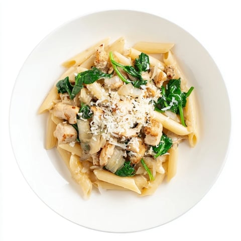 One-pot spinach and chicken pasta, a steaming bowl with vibrant greens and tender chicken.