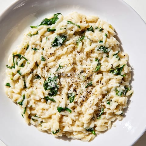 Creamy Spinach Orzo, a one-pan wonder, simmers with fresh spinach and Parmesan for a vibrant meal.