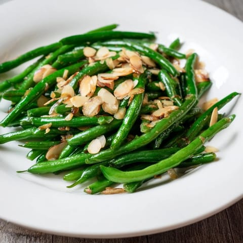 These vibrant sautéed green beans with garlic and almonds offer a delightful nutty crunch and savory flavors.