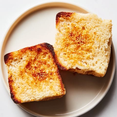 Warm and fluffy Sheet Pan English Muffins ready for buttering, split and toasted until golden.