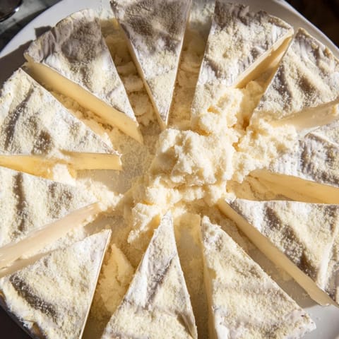The Snowcapped Range appetizer showcases Brie triangles topped with Parmesan, offering a delightful creamy flavor.