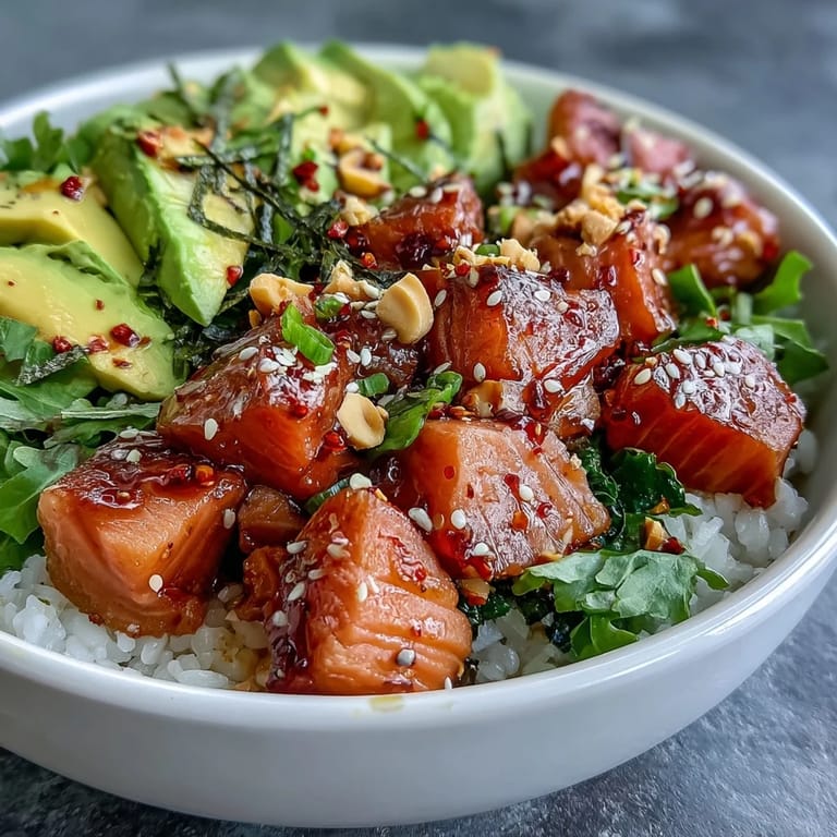 Seasoned sushi rice layered with tender salmon, avocado, and spring onions in a flavorful Avocado Salmon Bowl finished with sesame seeds.