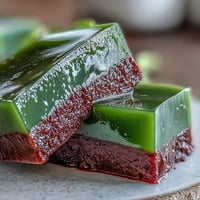 A vibrant slice of yokan Japanese red bean jelly with a delicate matcha green tea layer, served chilled for a refreshing dessert.